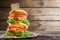 Double-decker burger on wooden background with space to menu