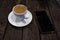 Double espresson in a white cup and smart phone