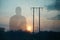 A double exposure of an atmospheric half transparent man looking at the sunset. Next to telegraph poles in the countryside