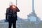 Double exposure of Engineer talking smartphone with oil refinery