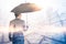 The double exposure image of the Businessmen are spreading umbrella during sunrise overlay with cityscape image. The concept of mo