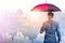 The double exposure image of the Businessmen are spreading umbrella during sunrise overlay with cityscape image. The concept of mo