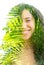 A double exposure of a smiling young woman`s portrait and palm tree leaves