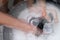 Double exposure woman washes clothes by hand in the soapy water on white background.