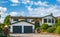 Double garage with short driveway in a summer. Family house with wide garage door and concrete driveway in front