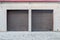 Double garage of white brick with blinds folding doors lower lock, lighting lamps and red visor, air vent at bottom, paved area.