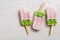 Double ice cream on a stick pink-green.Bitten off strawberry ice cream on a stick.Top view, space for text.