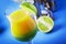 Double layer green yellow alcoholic cocktail with mango juice, rum, liqueur, lime and ice, blue background, copy cpase