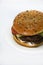 Double meat burger with vegetables on a white background. Delicious cheeseburger on a plate. Meat fast food. A large hamburger