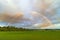 Double rainbow over endless green fields. scenic landscape. village scene