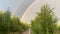 double rainbow over the village road and trees, summer landscape.