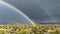 Double rainbow with rain falling in the desert