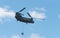 Double rotor, heavy airlift, military helicopter, in flight, carrying cargo.