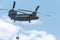 Double rotor, heavy airlift, military helicopter, in flight, carrying cargo.
