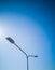 Double street lamp pole in front of nice blue sky