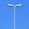 Double street lamp post on blue sky background