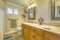 Double vanity with wooden cabinets inside a bathroom with small window