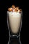 Double walled glass with coffee cocktail decorated with whipped cream and popcorn isolated on black