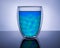 Double-walled insulated glass beaker, filled with blue and green liquid