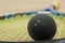 Double yellow dot squash ball on a racket