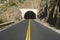 Double yellow-line leads to a tunnel through a mountain on highway 33 in Ojai, Ventura County California