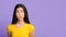 Doubtful Asian Girl Looking Aside At Copy Space On Purple Background