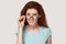 Doubtful red-haired girl take off glasses feeling hesitant