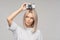 doubting about photos\' quality young attractive woman holding a camera on her head