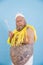 Doubting plus size man with crown and magic stick poses on light blue background