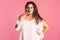 Doubting plus size model in white dress on pink background