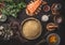Dough in baking form and ingredients for quiche or open faced savory pie with salmon on on dark rustic table background with