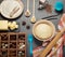 Dough in bowl, butter and other ingredients in box with cells, on gray background