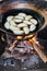 Dough dumplings frying in oil on wood burning stove. Asian food stalls in the market of Indein, Myanmar