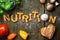 dough letters and vegetables on rustic wooden table, word nutrition