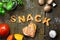 Dough letters and vegetables on rustic wooden table, word snack