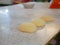 Dough mixed with sesame seeds on a table divided into round pieces ready to be cooked, deep fried, to make delicious deep-fried