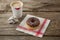 Doughnut and coffee on wooden plank