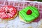 Doughnuts with green mint and pink strawberry frosting