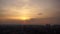 Dove flies close to camera with Kiev cityscape and dramatic sunset with spectacular cloudscape on background