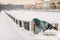 Dove sits on the parapet of embankment in winter during snowfall against the background of the old city