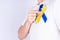 Down syndrome day, hands holding blue yellow ribbon awareness on chest support patient with illness disability