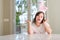 Down syndrome woman at home wearing easter rabbit ears very happy and excited, winner expression celebrating victory screaming