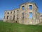 Downhill House in England Great Britain . Facade of a stone ruin . The blue sky can be seen through the window holes . Old