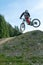 Downhill mountain biker jumping high and riding hard in Lenzerheide in the Swiss Alps