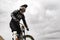 Downhill rider on a mountain bike in a mountain bike rides along the road in nature against the backdrop of the mountain