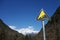 Downhill road sign with snow mountains