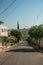 Downhill street view with sidewalk trees, walls and houses on a sunny day at San Manuel.