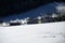 Downhill view of distant houses in a snowy environment