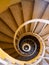 The downside view of a spiral staircase with handrail. Turning stairs in deep