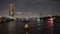 Downtown river night view, skyscrapers lights and boats cruise down the river